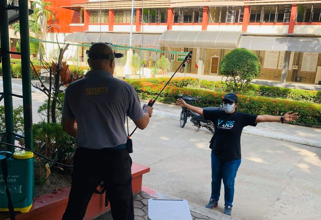 Entrants of EVSU Tacloban campus pass through a disinfectant spray protocol